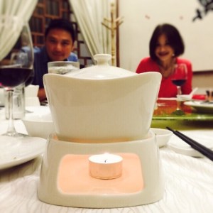 The grouper slices sit warm within the crock and hot soup is poured over it. 